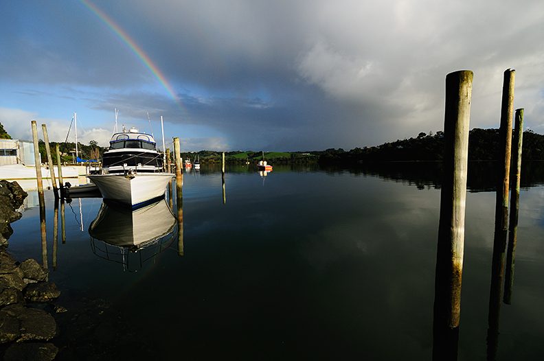 rainbow over bay and boat harbor