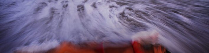 woman lyingon beach with oncoming wave